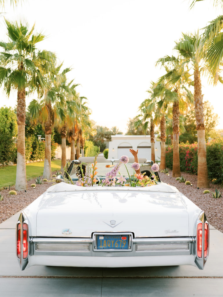 Getaway car for a California wedding with flowers and palm trees around